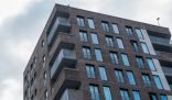 Low-angle view of a modern apartment building with multiple balconies, symbolizing the challenges and solutions in effective cleaning techniques for small apartment spaces.