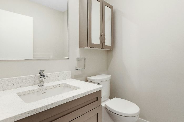 A neatly organized bathroom with a sparkling clean sink and toilet, emphasizing the importance of disinfection in frequently used spaces.