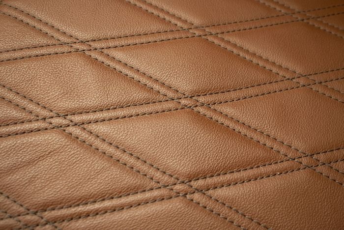 Detailed texture of stitched leather, emphasizing the importance of proper cleaning techniques to maintain its pristine condition.