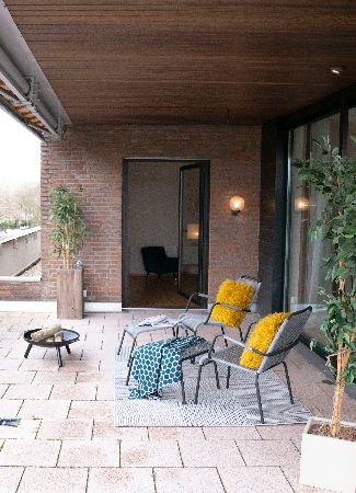 A chic patio space with modern furniture and clean paving, rejuvenated by professional cleaning services, ready for outdoor relaxation and social events in London.