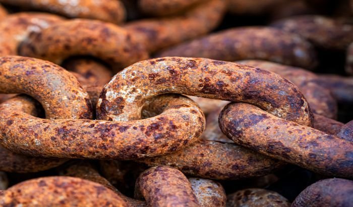 Close-up of heavily rusted metal chains demonstrating the need for rust stain removal techniques.