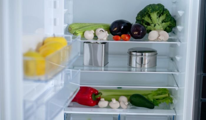 Fresh vegetables and containers in a clean refrigerator, showcasing the results of professional cleaning strategies for removing stains and odours in a London home.