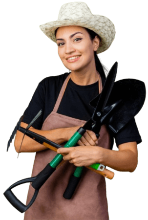 A cheerful female gardener equipped with pruning shears and a spade, wearing a hat and apron, ready to tackle garden clearance tasks with expertise and a smile.