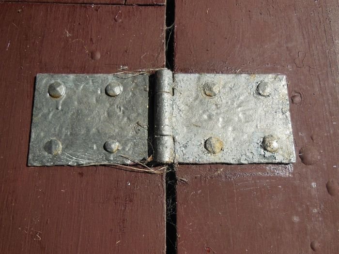 A close-up image of a metal hinge on a wooden surface, highlighting potential rust-sensitive areas suitable for treatment with natural remedies.