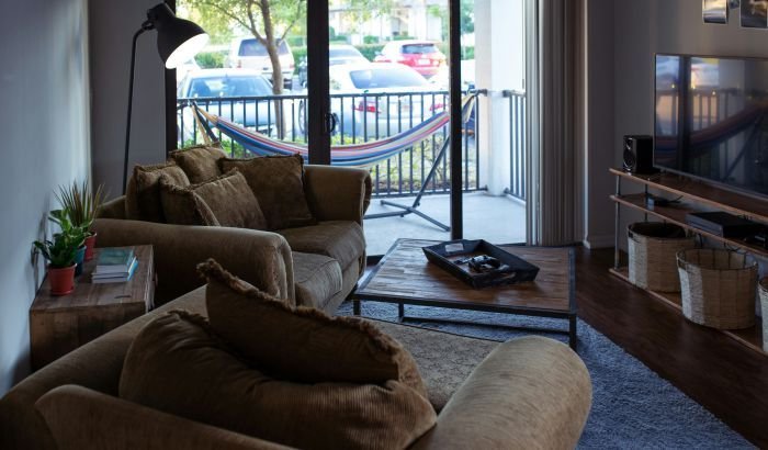 A cozy yet cluttered living room with a couch full of throw pillows, highlighting the need for clutter management for better health.