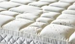 Close-up of a mattress stained with spots, highlighting the importance of effective cleaning and stain removal techniques for a fresher sleep experience.