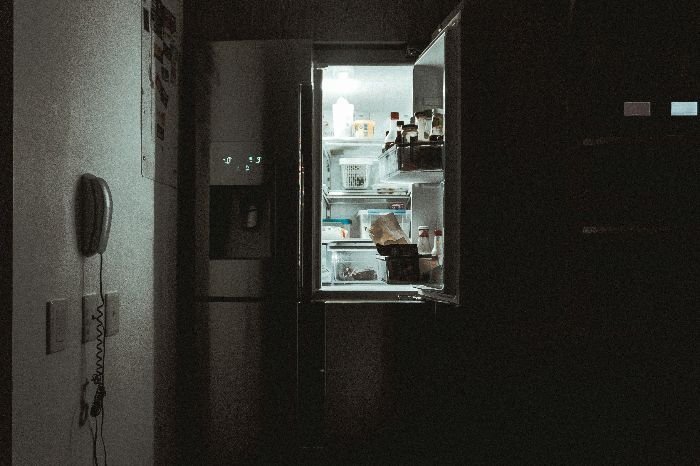 Open modern refrigerator with shelves illuminated, highlighting the need for careful scrubbing and wiping down techniques to maintain a clean and hygienic fridge interior.