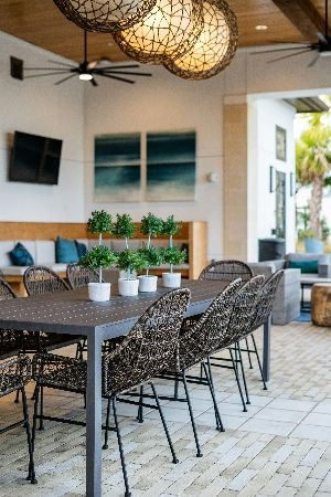 A stylish outdoor dining area with clean interlocking paving stones, featuring a well-maintained table setting and inviting chairs, all enhanced by professional patio cleaning services for a perfect entertainment space.
