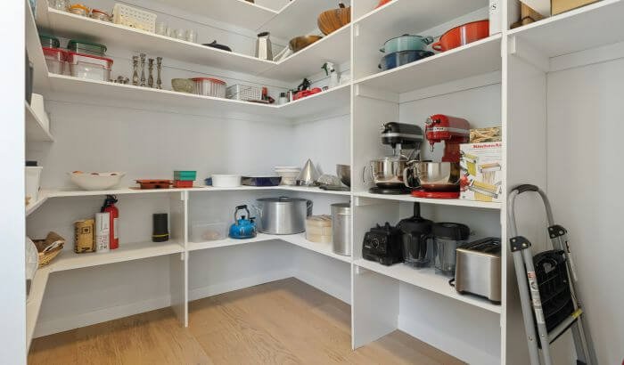 A clean and organized utility room with neatly arranged shelves and appliances, showcasing effective storage and tidying strategies.