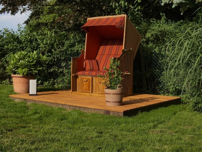 Cozy outdoor seating area on a wooden deck, illustrating the comfort and functionality of decks and patios for different types of activities and preferences.