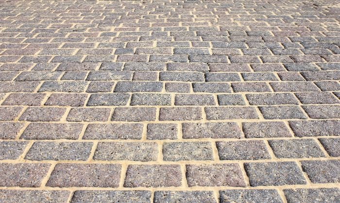 Close-up view of a patterned brick patio highlighting the types of materials that can be deep cleaned, ideal for a guide on cleaning concrete, wood, and tile patios.