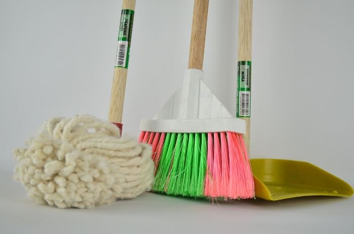 A collection of essential cleaning supplies, including a mop, broom, and dustpan, illustrating the importance of gathering all necessary tools before starting a deep cleaning session for efficiency and effectiveness.