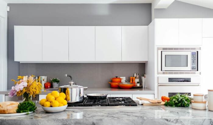 A stylish and well-maintained kitchen workspace, fully equipped with cooking utensils and vibrant ingredients, demonstrating the importance of maintaining cleanliness for food safety and hygiene.