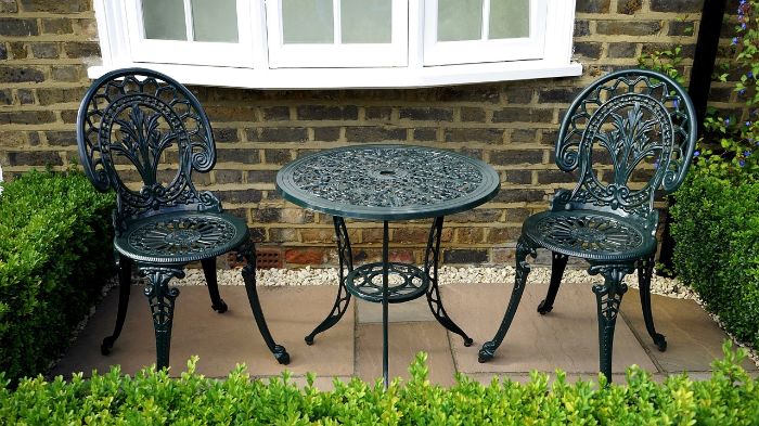 Quick Tips for Tidying Outdoor Spaces 4 A clean and tidy patio with elegant wrought iron furniture, illustrating the advantages of hiring professional help for thorough and efficient outdoor cleaning tasks.