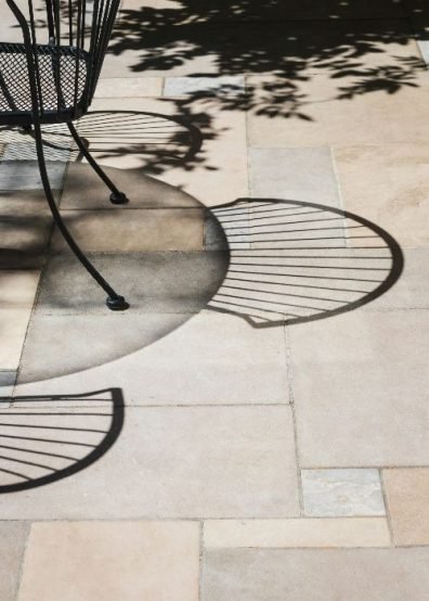 Artistic shadow of a chair cast on a clean patio, symbolizing the effectiveness of patio cleaning services in Putney, SW15 that rejuvenate and enhance outdoor living spaces.