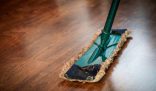 A mop cleaning a wooden floor, illustrating time-saving tips for deep cleaning to maintain a spotless and organized home efficiently.