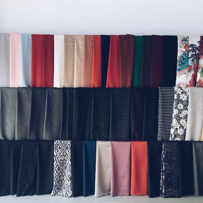 A variety of colorful fabric swatches arranged in rows, illustrating the need for different approaches to clean up makeup stains based on fabric type.