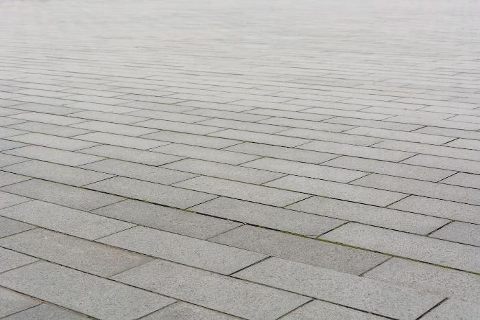 Close-up of a patio made from grey pavers, illustrating the definition and characteristics of a patio as a ground-level outdoor space made from materials like concrete, pavers, or stone.
