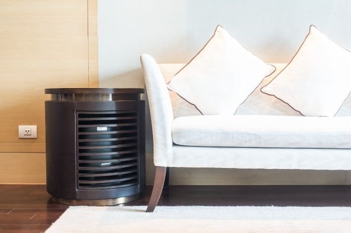 Air purifier placed in a living room, showcasing its role in improving air quality by removing dust, pollen, and allergens.