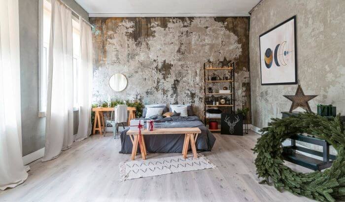 A stylishly decorated shared living space with a bed, shelves, and a wreath, illustrating the importance of effective cleaning strategies to maintain cleanliness and organization in shared areas.