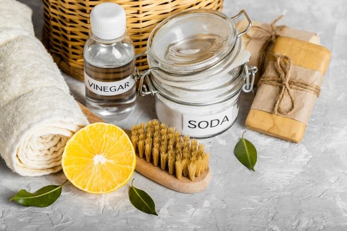 Natural cleaning products including vinegar, baking soda, and a brush, illustrating how to identify child-safe cleaning products.