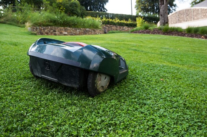 An automatic lawn mower in action, illustrating one of the innovative gardening gadgets that can make maintaining a garden easier and more efficient.