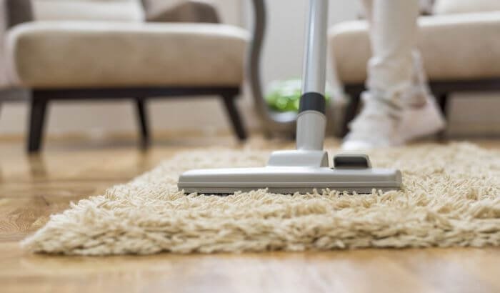 Vacuuming a carpet to avoid common cleaning mistakes during end of tenancy in London, ensuring a spotless finish.