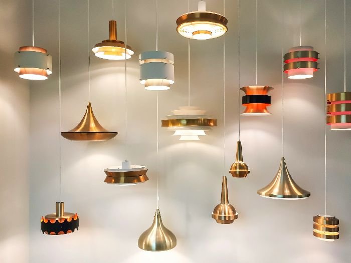 Various types of light fixtures in different styles and materials, illustrating the need for specific cleaning methods and products for glass, metal, and plastic fixtures.