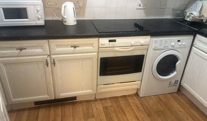 Clean kitchen area after end of tenancy cleaning in Church End, NW10, showing oven, cabinets, and countertops.