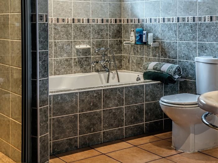 Clean and organized bathroom with a tidy bathtub and toilet, illustrating tips for freshening up the toilet and shower.