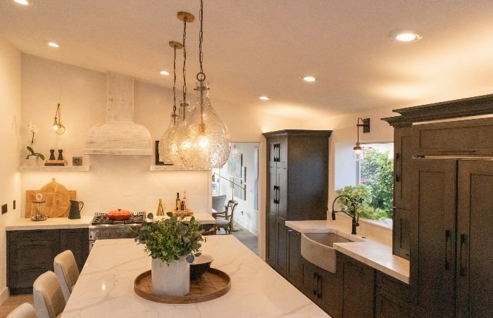 Modern kitchen with multiple light fixtures, highlighting the importance of safety precautions such as turning off electricity and ensuring proper ventilation while cleaning.