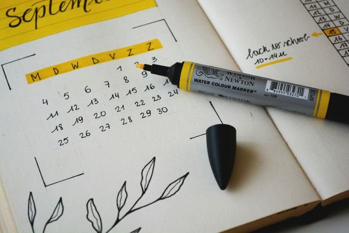 Calendar and marker highlighting important dates, symbolizing the use of online tools for tracking trends and booking information in vacation rentals.