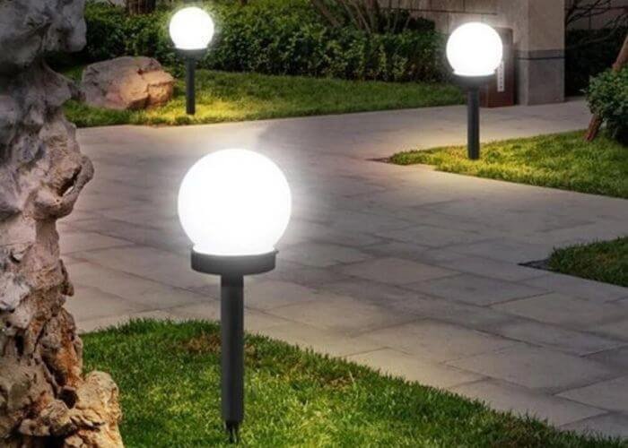 Weather-resistant garden lights illuminating a pathway, showcasing durable, sealed fixtures designed to withstand London’s unpredictable weather.