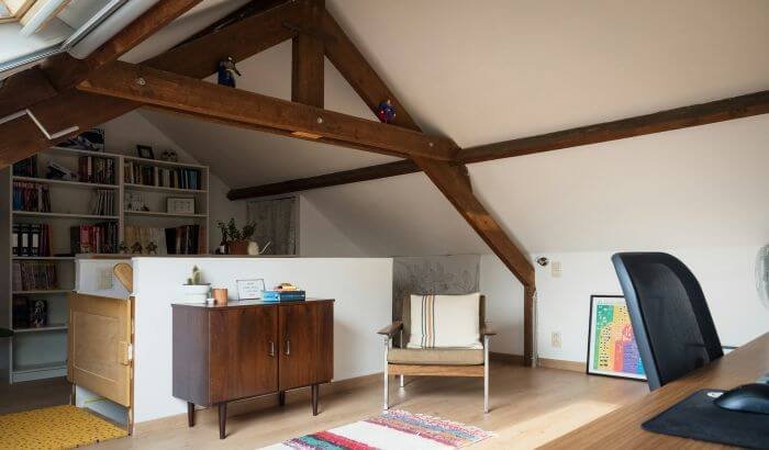 Spacious and organized attic space with wooden beams, showcasing an efficient setup for decluttering and cleaning