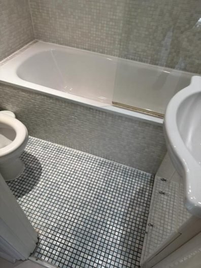 Clean bathroom with a spotless tub and tiled floor after end of tenancy cleaning in Battersea, SW8