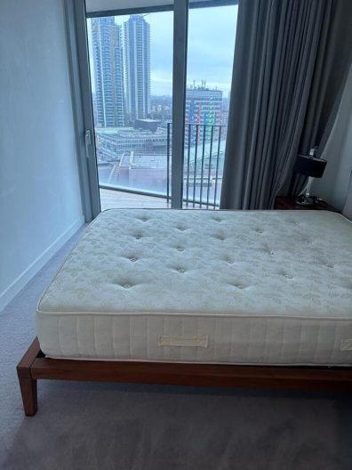 Clean bedroom with mattress after end of tenancy cleaning in Canary Wharf, E14, with city skyline view