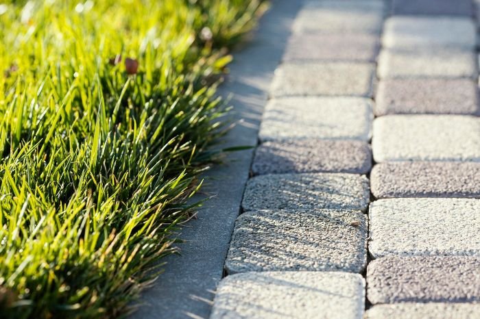 Close-up of permeable hardscaping materials in a garden, highlighting the benefits of improved water drainage, healthier soil, and reduced runoff.