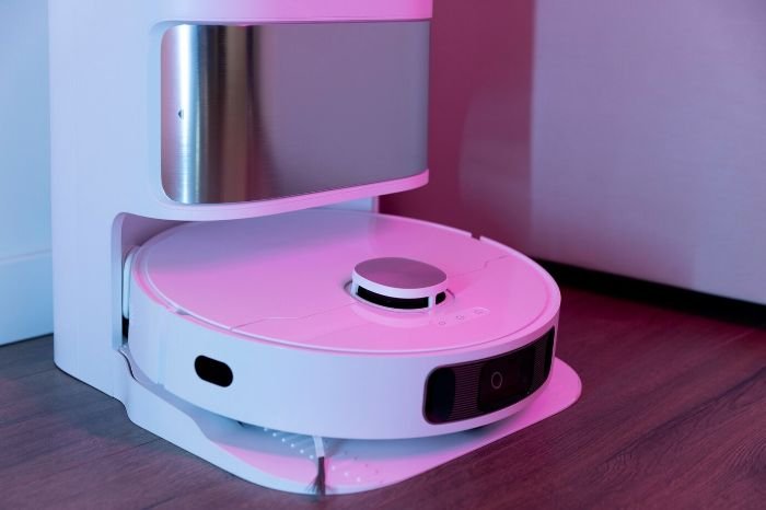 A robotic vacuum cleaner docked in its charging station, ready to automate floor cleaning in modern households, showcasing convenience and efficiency in home maintenance.