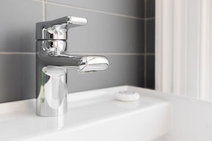 Clean chrome faucet in a bathroom, highlighting autumn bathroom cleaning tips to prevent mould and maintain hygiene.