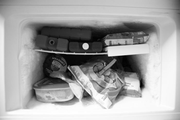Iced-up freezer with various frozen items, illustrating the importance of defrosting and deep cleaning the fridge and freezer to maintain freshness and prevent odours.