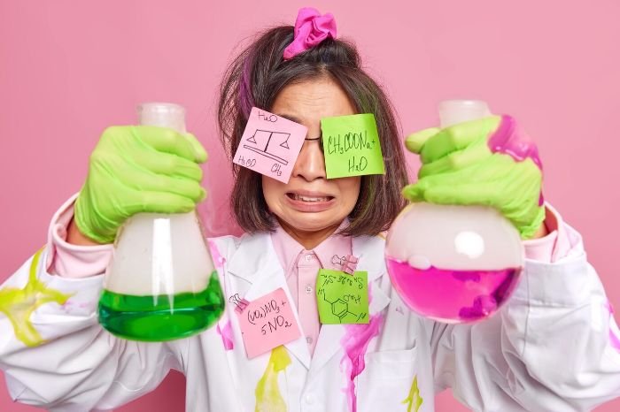 Person in a lab coat with spilled chemicals and sticky notes, demonstrating the dangers of mixing cleaning agents like bleach and ammonia, which can create harmful fumes.