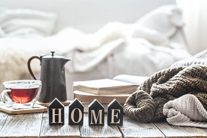 Cozy winter setup with blankets, a warm drink, and decor, highlighting the importance of setting up throws and blankets for added warmth and comfort.