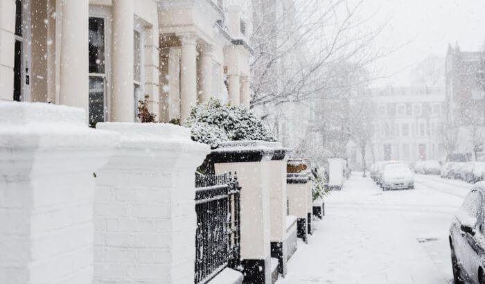 Snow-covered London street with homes, ideal for illustrating tips on maintaining a clean and cozy winter home.