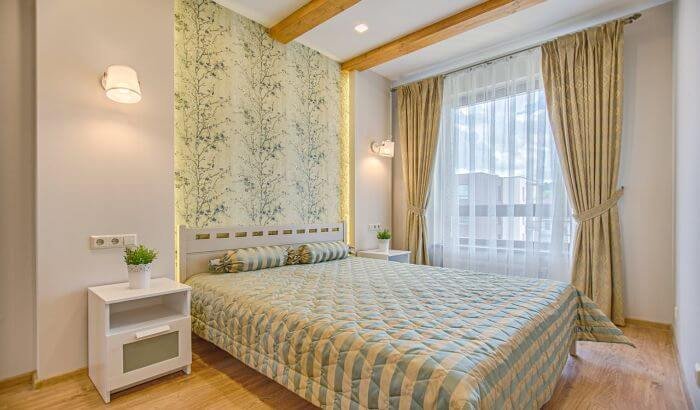 A clean, well-lit bedroom with large windows and neatly arranged curtains, highlighting the importance of regular curtain cleaning to remove hidden dirt and maintain a healthy living environment.