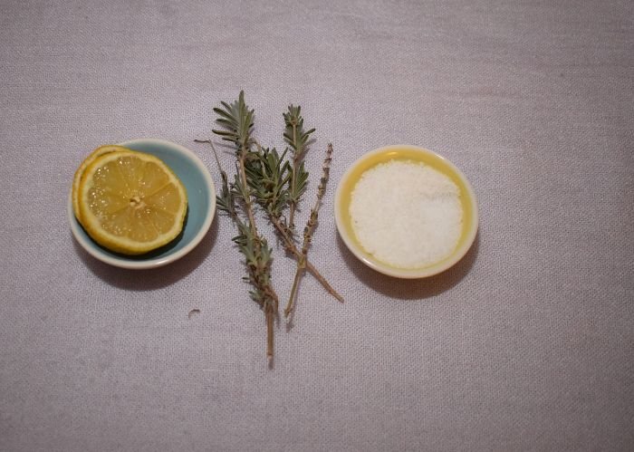 Eco-friendly cleaning ingredients: lemon, baking soda, and lavender sprigs for non-toxic home cleaning.