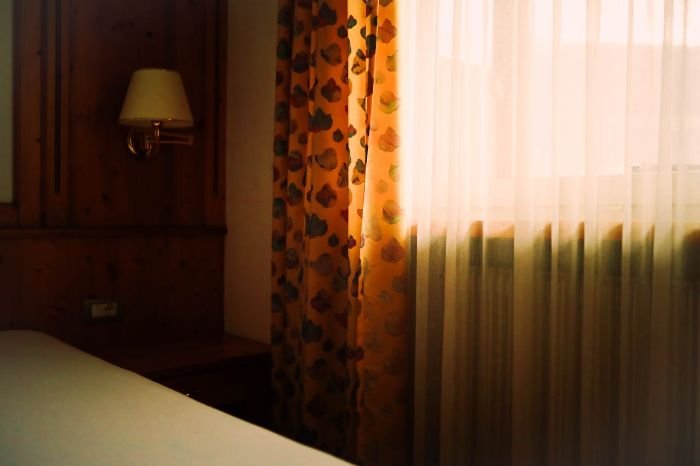 Sunlit room with curtains, emphasizing the importance of regular cleaning to extend curtain life and prevent dirt and mold buildup.