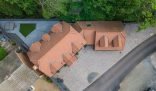 Aerial view of a house with a clean driveway, illustrating the importance of driveway cleaning for a thorough patio cleaning.