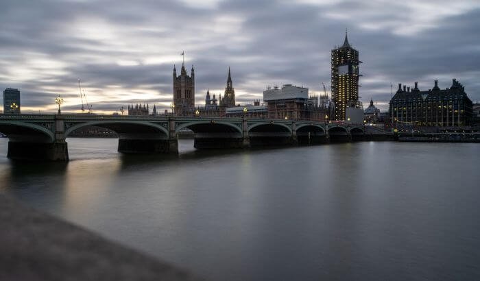 View of London skyline featuring the Thames and Westminster Bridge, representing the impact of minimum wage increases on cleaning services in London.