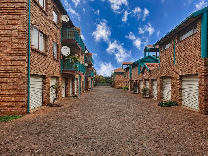 Clean brick driveway between apartment buildings, highlighting the importance of reducing grime build-up on outdoor surfaces through regular cleaning and maintenance.