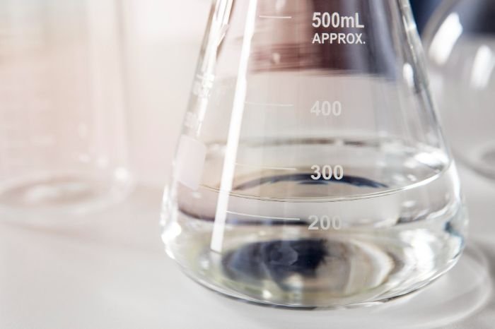 Close-up of a beaker with hydrogen peroxide solution, highlighting best practices for safe dilution and handling during cleaning.